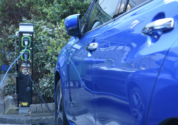 Blue car on charge next to charge point